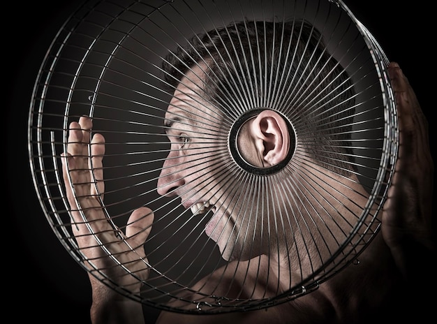 Hombre escuchando desde el concepto de jaula de pájaros