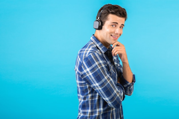 Hombre escuchando música con auriculares inalámbricos divirtiéndose con estilo moderno en azul