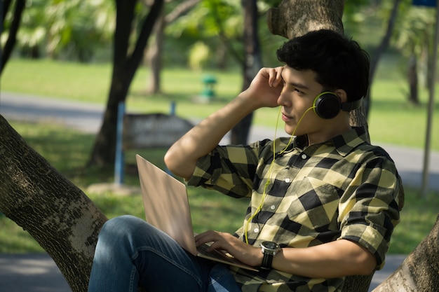 hombre escuchando música por auriculares en el parque