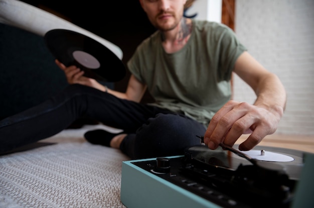 Foto hombre escuchando música de un disco de vinilo