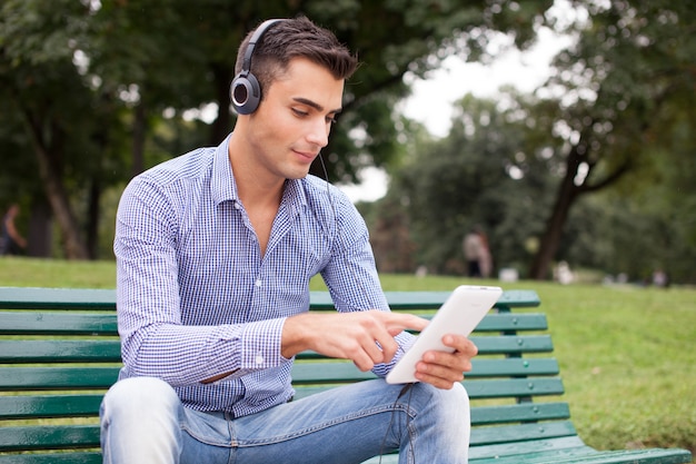Hombre escuchando música en un parque de la ciudad