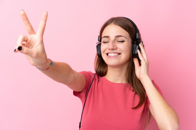 Hombre escuchando música sobre pared aislada