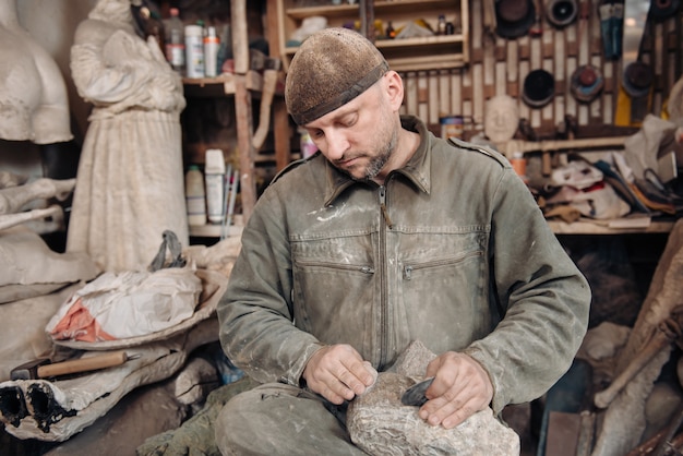 Hombre escultor trabajando en su taller