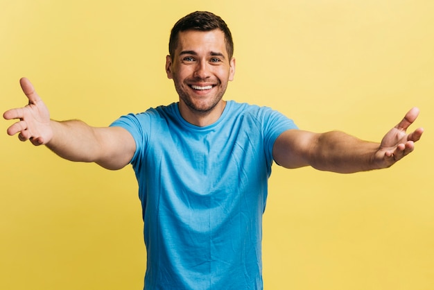 Hombre esperando un abrazo con fondo amarillo