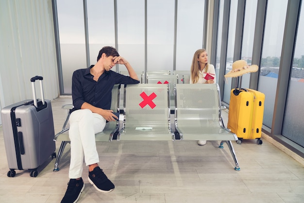 hombre esperando para volar en el aeropuerto con máscara