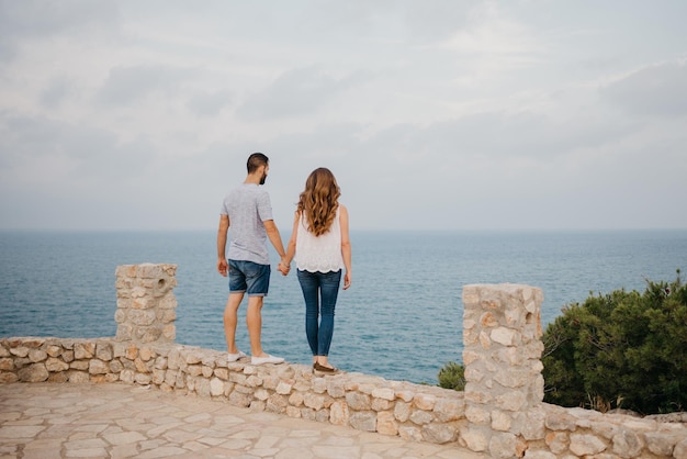 Un hombre está abrazando a su novia en el parque highland cerca del mar en España