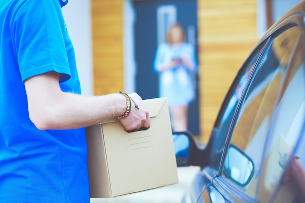 Un hombre está abriendo una caja de un coche.