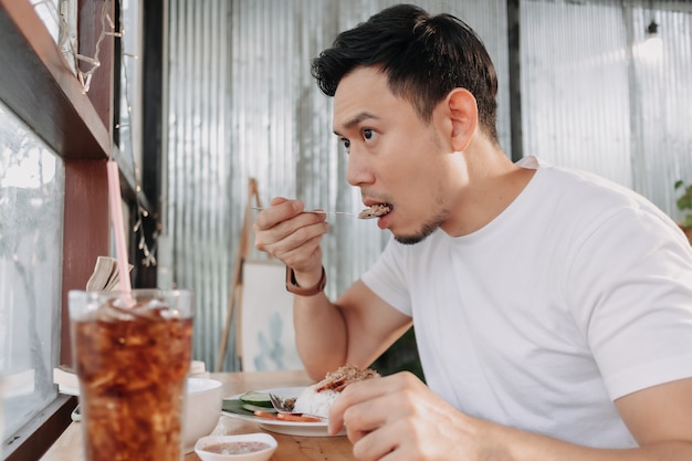 El hombre está almorzando en el restaurante sentado junto a la ventana