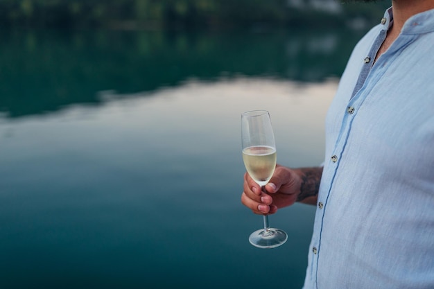 El hombre está bebiendo vino rodeado de hermosa naturaleza.