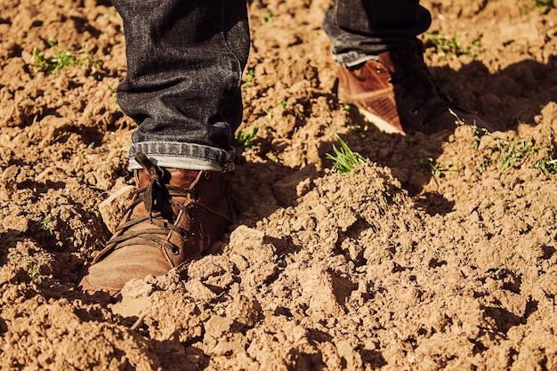 El hombre está caminando en campo arado