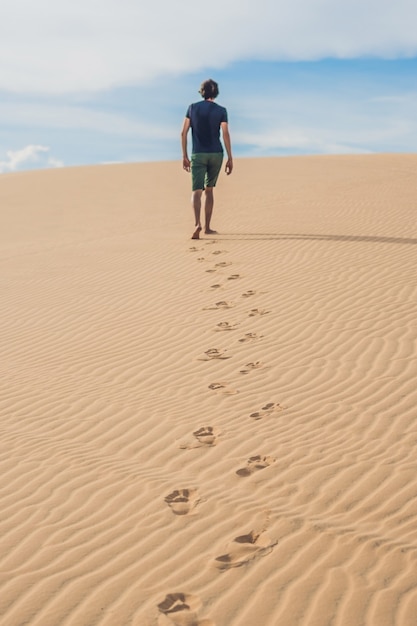 Un hombre está caminando en el desierto de Vietnam, Mui Ne