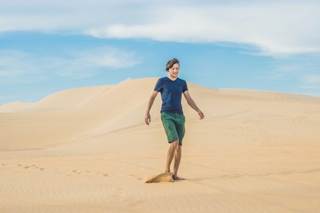 Un hombre está caminando en el desierto de Vietnam, Mui Ne