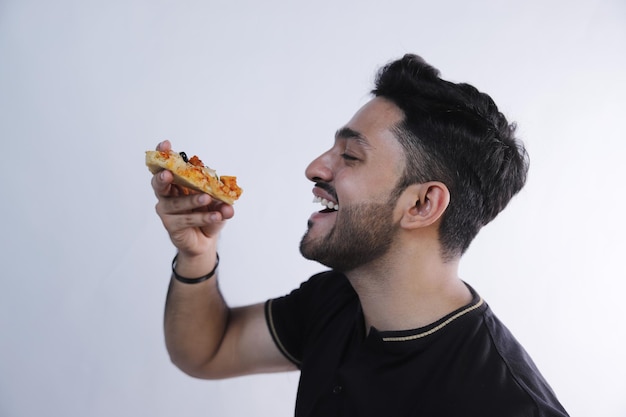 Un hombre está comiendo una hamburguesa con un fondo blanco y usando una camiseta polo negra con un tiro de primer plano