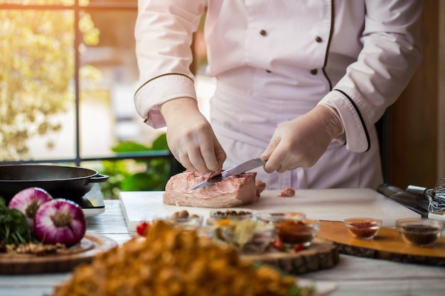 El hombre está cortando carne cruda.