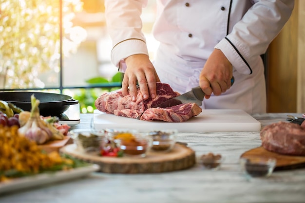 El hombre está cortando carne. Mano con cuchillo de cocina. Solomillo para un delicioso bistec. Qué cocinar de carne de res.