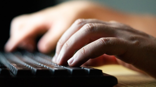 El hombre está escribiendo en el teclado.