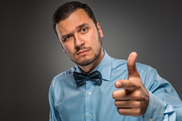 El hombre está gesticulando con la mano, apuntando con el dedo a la cámara