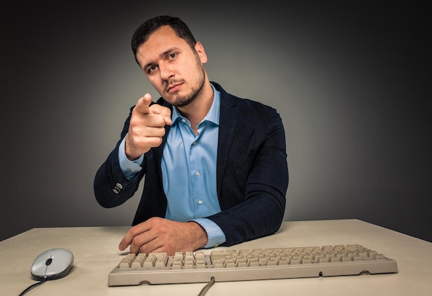 El hombre está gesticulando con la mano, apuntando con el dedo a la cámara