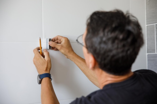 Un hombre está haciendo reparaciones en el baño.