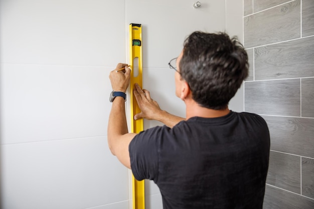 Un hombre está haciendo reparaciones en el baño.