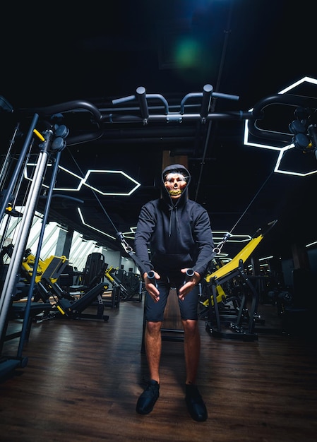 El hombre está haciendo sentadillas en el gimnasio.