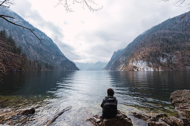 el hombre está mirando un gran lago con dos montañas al fondo