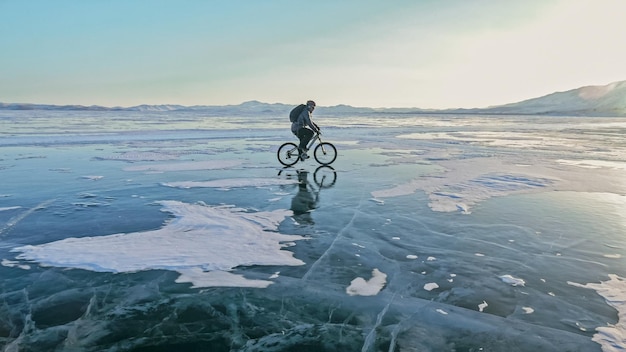 El hombre está montando bicicleta en el hielo Hielo del lago Baikal Rid congelado