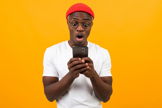 El hombre está muy sorprendido mirando la pantalla de su teléfono inteligente.