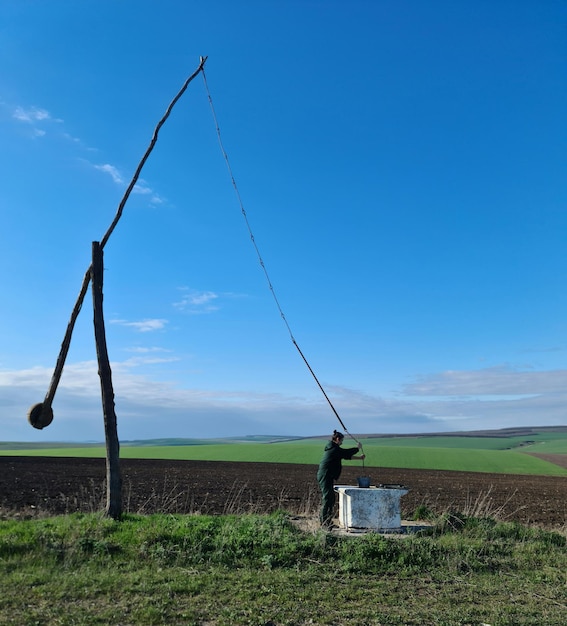 Un hombre está parado en un campo con un gran poste que dice "la palabra" en él.