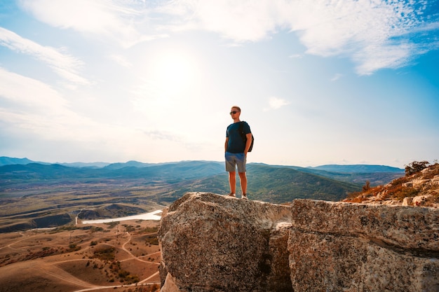 Un hombre está parado sobre una roca en el valle de Koktebel en Crimea