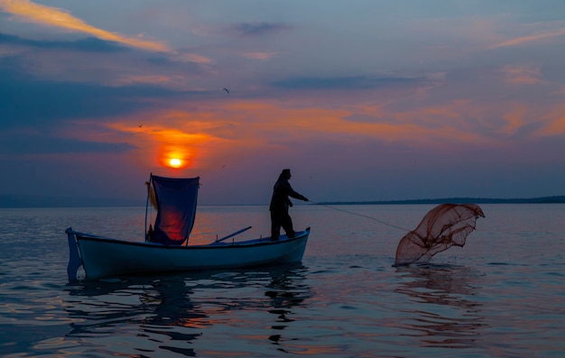 un hombre está pescando en un barco con una red que dice pescador en él