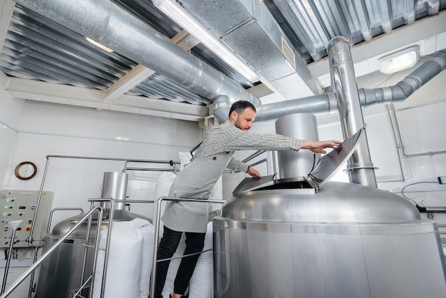 Un hombre está preparando cerveza en una cervecería.