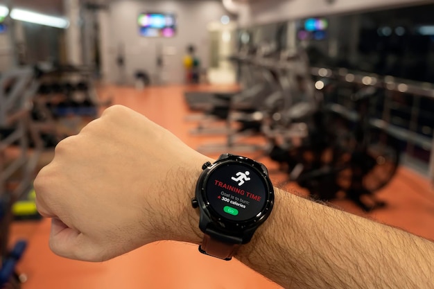 un hombre se está preparando para comenzar en una cinta de correr reloj inteligente en la mano del atleta Aplicaciones para reloj inteligente para entrenamiento muscular al aire libre