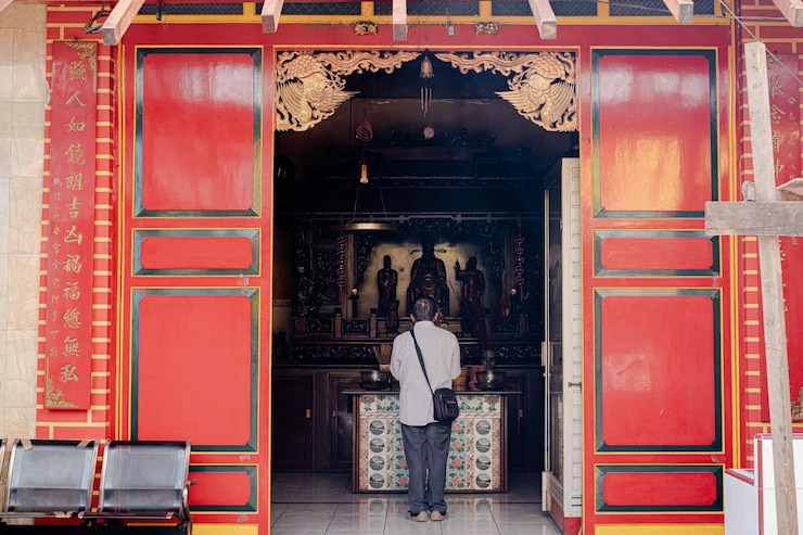 Un hombre está rezando en el templo confuciano chino