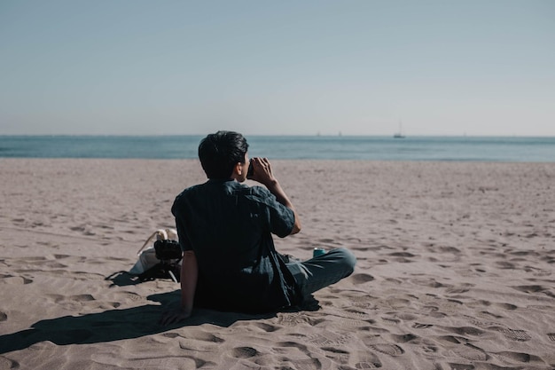 un hombre está sentado en la playa