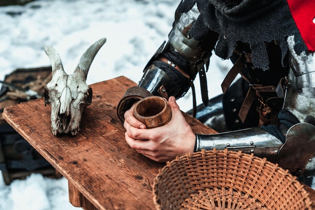 El hombre está sosteniendo una taza de madera.