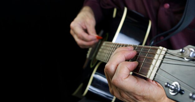 un hombre está tocando una guitarra con un marcador rojo.