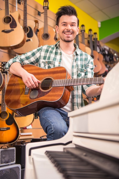 El hombre está tocando la guitarra en la tienda de música.