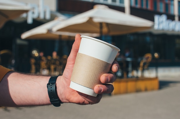 Un hombre está tomando café en un restaurante al aire libre.