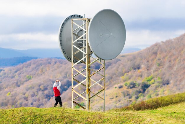 El hombre está tomando fotos de una antena en las montañas