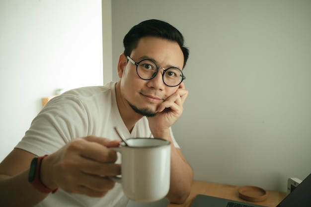 El hombre está trabajando con la computadora portátil en su apartamento en concepto de trabajo desde casa.