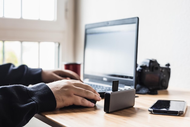 El hombre está trabajando en la edición de fotos con su equipo.