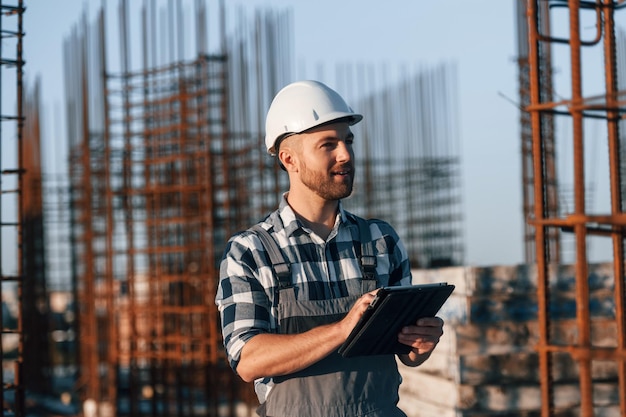 El hombre está trabajando en el sitio de construcción durante el día