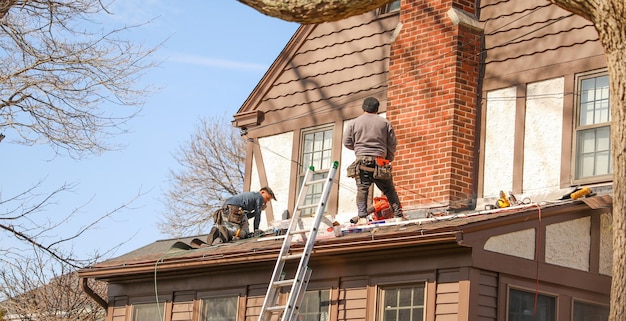 Un hombre está trabajando en un techo que está cubierto con una lona.