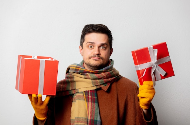 Foto hombre de estilo en abrigo y bufanda con caja de regalo