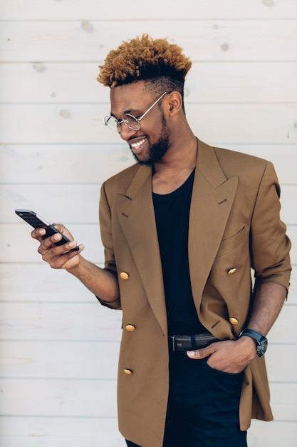 Hombre con estilo en la chaqueta con smartphone