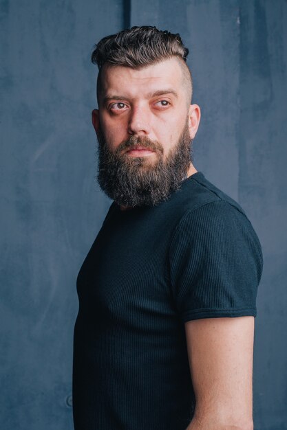 Hombre con estilo hipster barbudo. Retrato de un hombre moreno con barba. Corte de pelo elegante para un hombre.