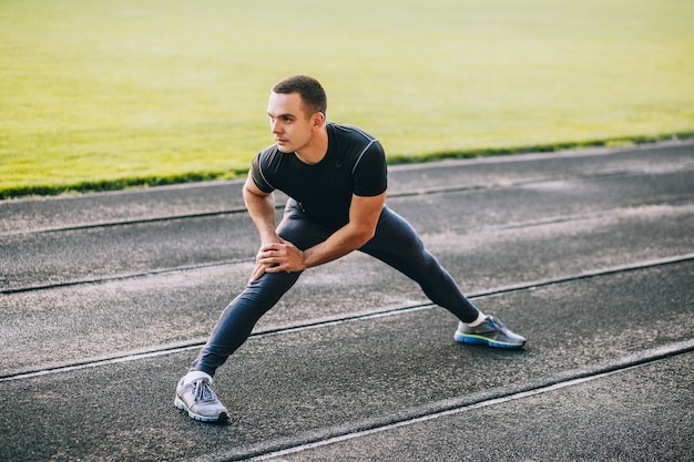 el hombre estira el cuerpo antes de correr