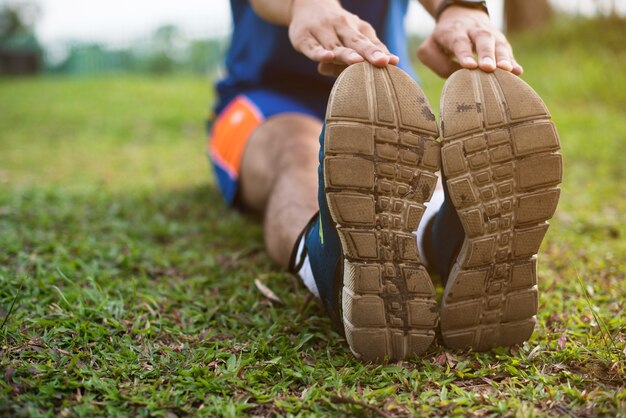 Hombre estirando para calentar antes de correr o hacer ejercicio. Fitness y concepto de estilo de vida saludable.