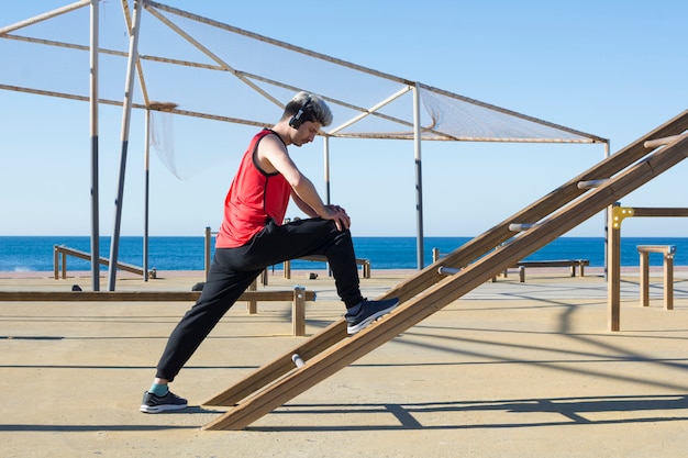 Hombre estirando sus músculos antes de comenzar a practicar deportes al aire libre